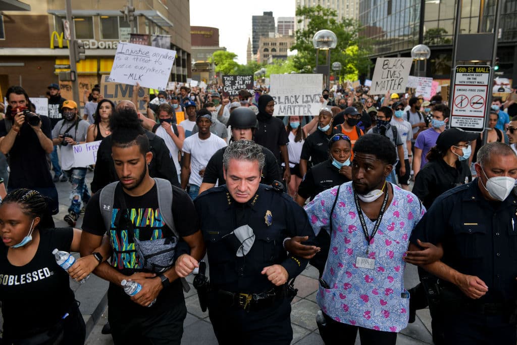 El jefe de policía de Denver Paul Pazen marcha codo a codo con las personas que protestan por la muerte de George Floyd, el pasado lunes 1 de junio de 2020 en Denver, Colorado.