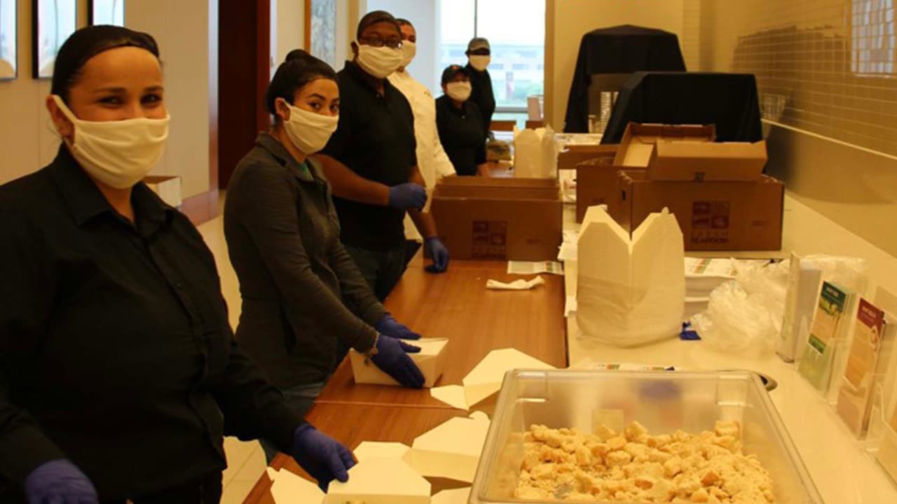 Los voluntarios de Second Servings distribuyen los alimentos respetando las reglas de distanciamiento social en esta crisis del coronavirus.