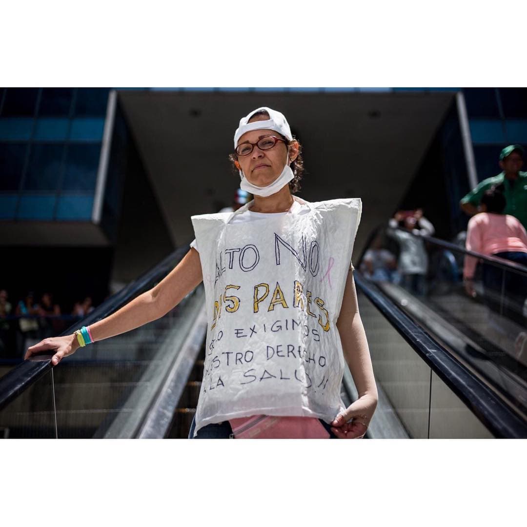 <b><a href="https://www.instagram.com/p/BUaU6O3g4Pc/?taken-by=prodavinci">Mildred Varela</a>, 46 años, paciente oncológica, activista de la Asociación Civil Conquistando la Vida. </b>“Tengo cáncer de mama. Fui diagnosticada en octubre de 2014 y todavía estoy en tratamiento. Ya tener la enfermedad es difícil, pero 
<b>ser un paciente oncológico en Venezuela es una odisea</b>. Dios es el que me ha dado la fortaleza para seguir. Uno intenta soportar la parte emocional y te dices a ti mismo: 'todo va a pasar, voy a estar bien'. En las noches me dan ataques de pánico y se me quitan orando, porque ni siquiera puedo tomar un Rivotril para calmarme. ¡No lo consigues en ninguna parte! Me hago el tratamiento porque me han donado los bloqueadores hormonales, que necesito tomarlos por cinco años y debería conseguirlos en el Seguro Social. Uno va una y otra vez y te dicen que no hay. En lo que va de año sólo he podido retirar mis medicamentos en el Seguro Social una vez, a principios de abril, y eso fue porque los pacientes protestamos en la farmacia de alto costo. Ese día no me querían dejar pasar porque llevaba una camiseta descubierta. Un mototaxista que estaba allí me prestó su chaqueta. Entré a la farmacia oliendo a sol, ¡pero no me importó! Luego me dijeron que como mi récipe estaba un poco roto no me darían mi medicina y les respondí que si no lo hacían me iba a poner a gritar. Y así fue que me la dieron. 
<b>Uno está aquí, en la protesta, porque quiere luchar por su derecho a la salud, pero como paciente te duelen los huesos</b>, tienes dolores de cabeza constantes y mucho reflujo”. Testimonio y foto: 
<a href="https://www.instagram.com/indirapop/">Indira Rojas</a> y 
<a href="https://www.instagram.com/@aka2863">Andrés Kerese</a>.