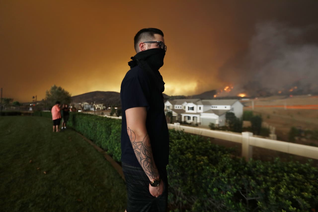 Moe Blythe observa el fuego que se aproxima a su casa en Corona, en el sur de California.