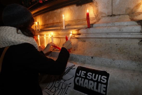 Cientos de personas prendieron velas para rendir tribudo a las doce víctimas del asalto.