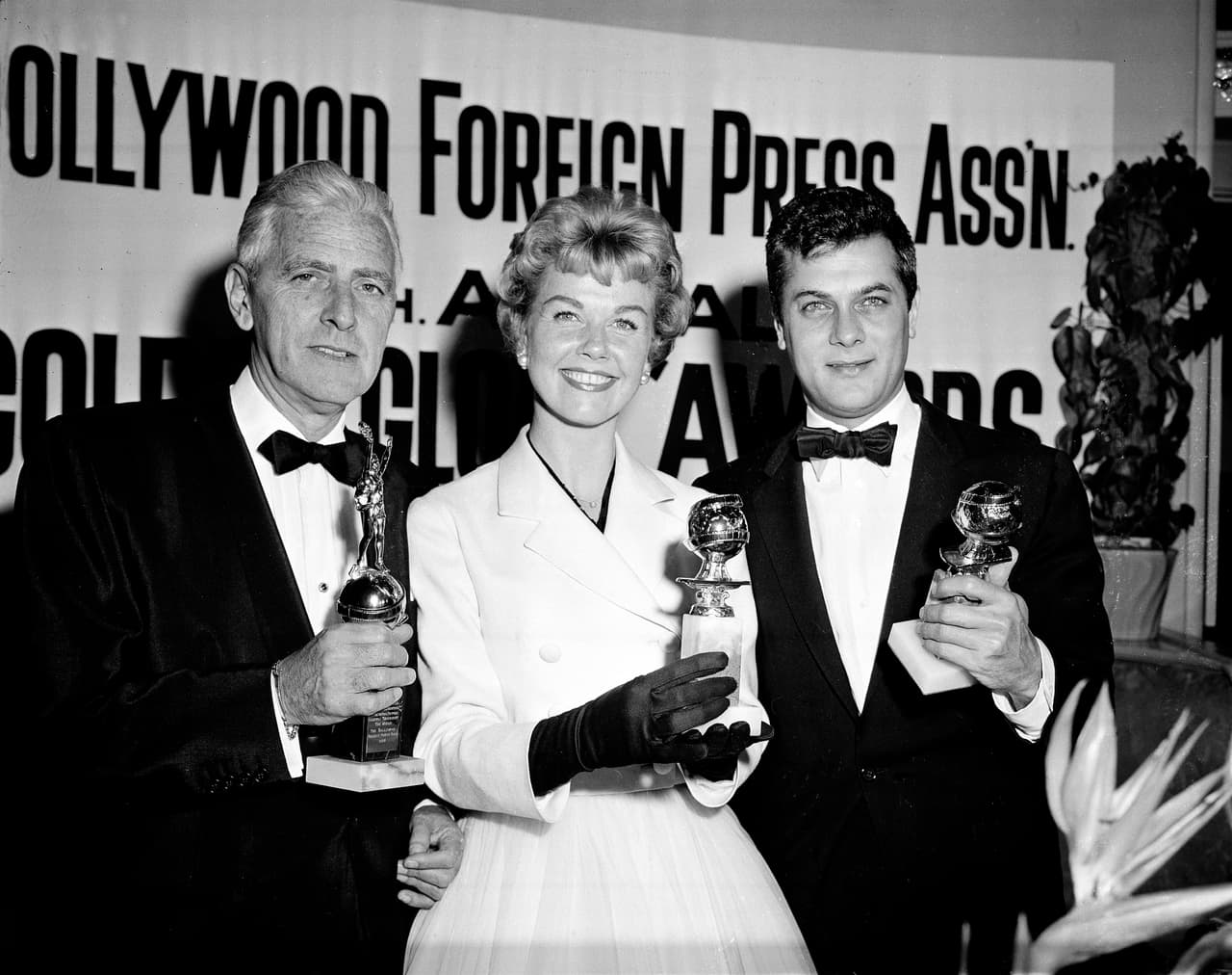 En esta foto de archivo del 26 de febrero de 1958, la actriz Doris Day junto a Tony Curtis y Buddy Adler posan con sus premios presentados por la Asociación de la Prensa Extranjera de Hollywood en su cena anual en el Coconut Grove de Los Ángeles.
<br>