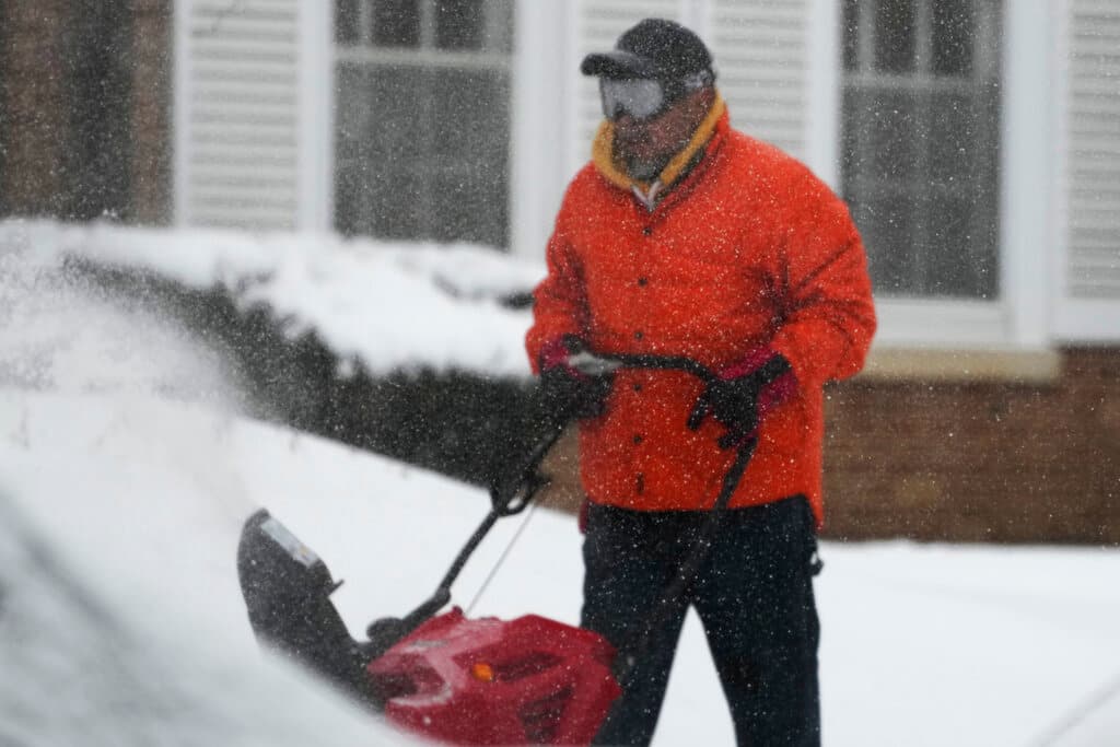 Un hombre barre la nieve en una calle de Evanston, Illinois.