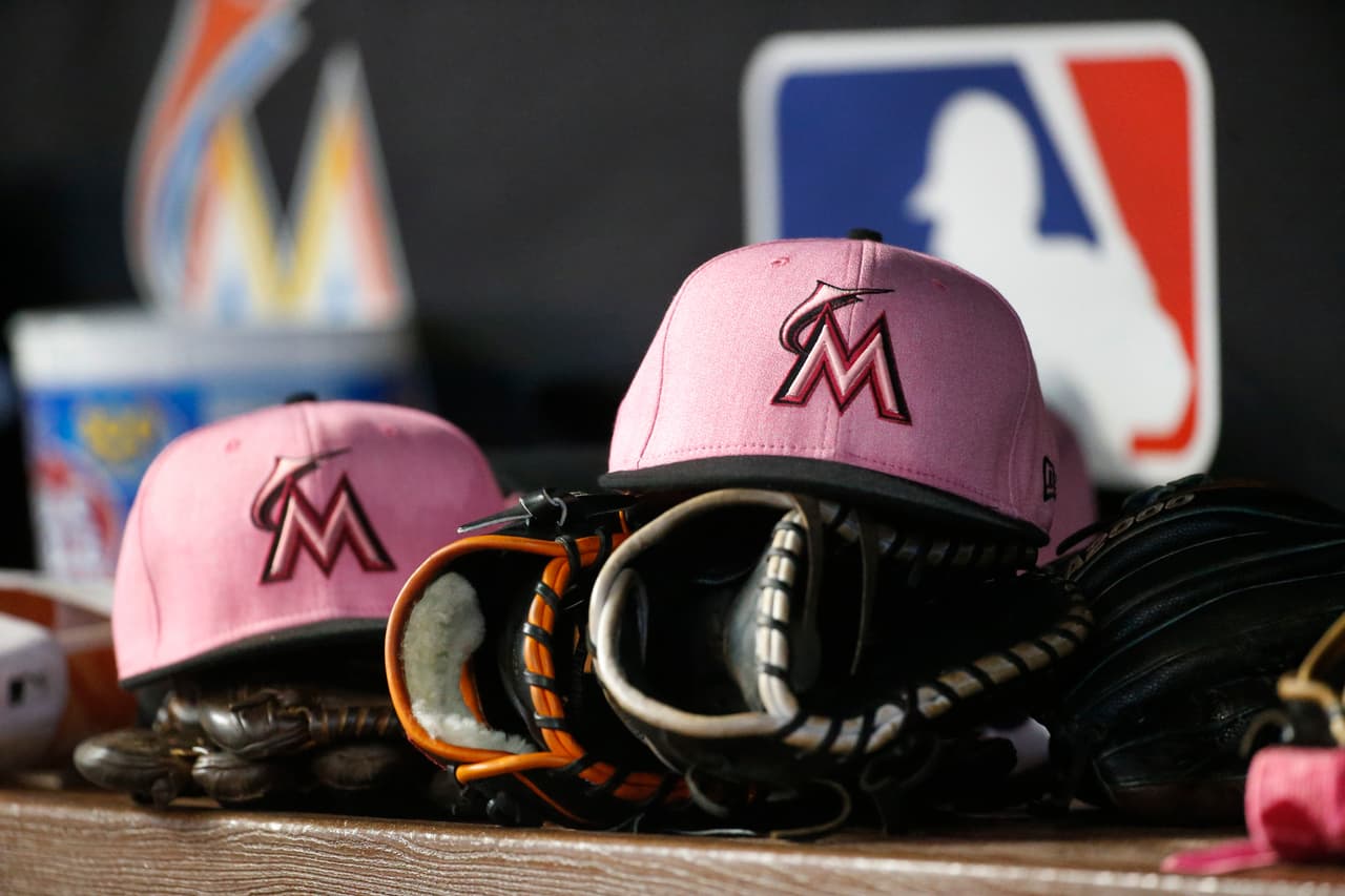 Pink caps in honor of Mother's Day and breast cancer awareness are shown in the Miami Marlins dugout during the ninth inning of a baseball game against the Atlanta Braves, Sunday, May 13, 2018, in Miami. The Braves defeated the Marlins 4-3. (AP Photo/Wilfredo Lee)