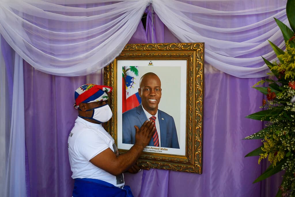 Un hombre toca un retrato del fallecido presidente haitiano Jovenel Moïse en el exterior de la catedral donde se celebra una misa en su memoria en Cap-Haitien, Haití, el jueves 22 de julio de 2021. Moïse fue asesinado en su casa el 7 de julio.