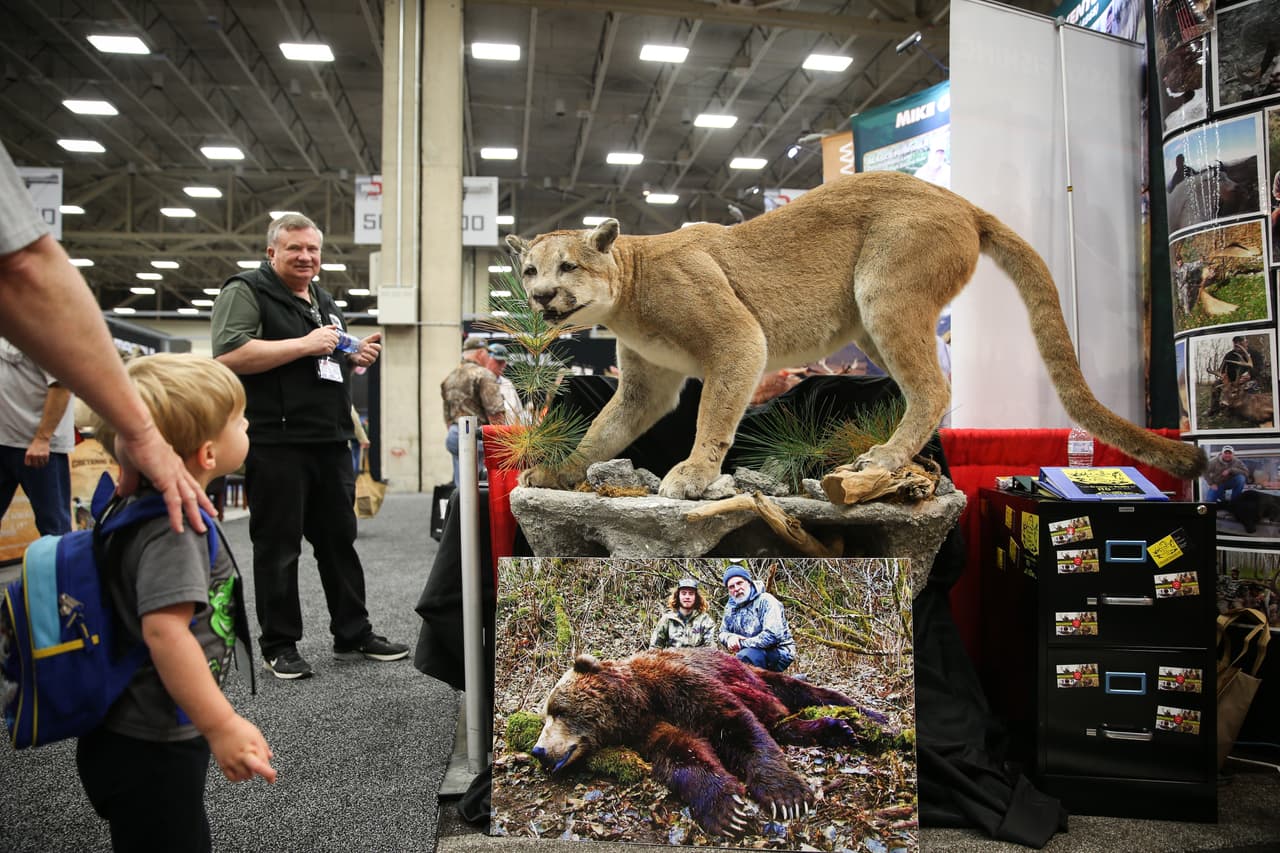 Los visitantes más jóvenes disfrutan de una exhibición de animales falsos de cacería, una de las 800 exposiciones de la convención.