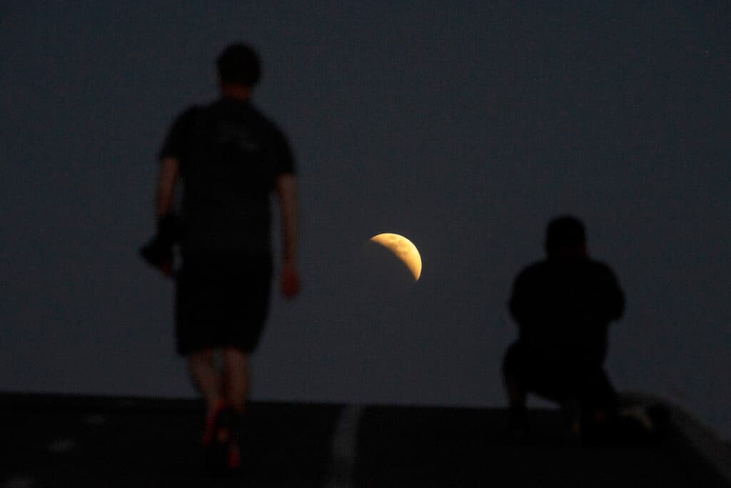 Personas toman fotos de la primera 'luna de sangre' que coincidió con el eclipse, desde Irwindale, California.