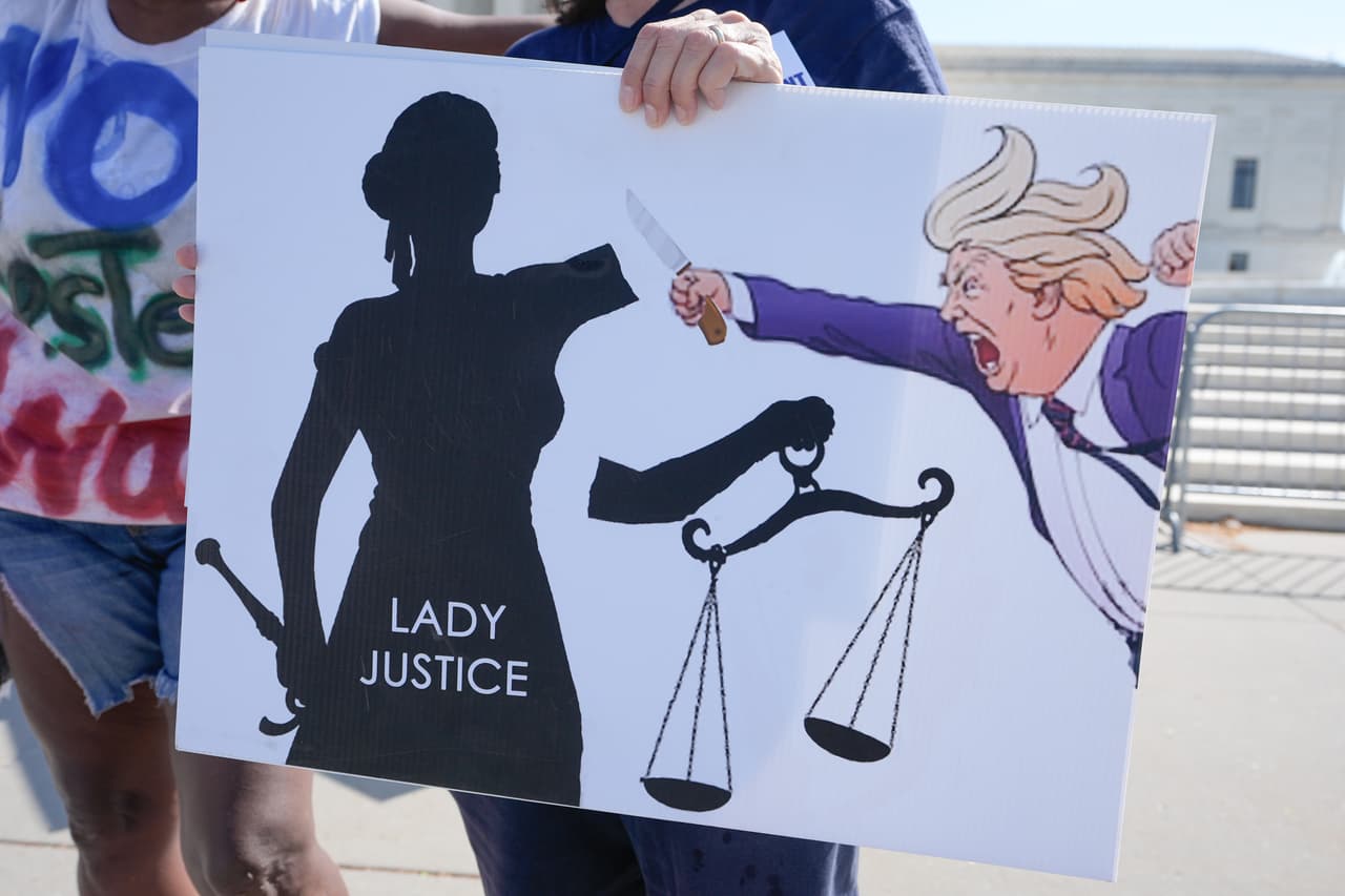 Diversas pancartas pudieron verse en el Capitolio, una de ellas muestra a la justicia representada como mujer con los ojos vendados, a la cual el presidente Trump le corta un brazo.
