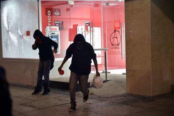Encapuchados realizan destrozos en un banco luego de la marcha por Ayotzinapa.