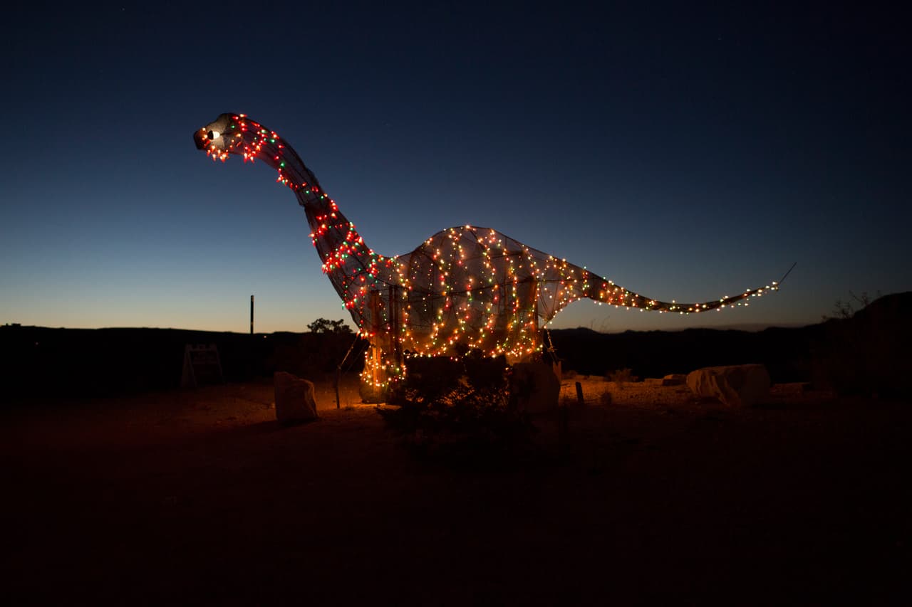 Una figura de dinosaurio iluminada, fuera de una tienda en una autopista de Terlingua, Texas, muy cerca de límite con México. 27 de marzo de 2017.