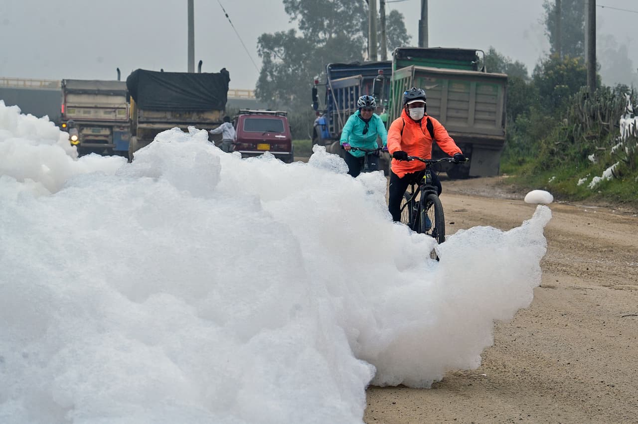 A distancia parece un espuma blanca inofensiva, pero en realidad
<b> se trata de una acumulación masiva de contaminantes con forma de algodón </b>que desbordó un río e 'invadió' una 
<a href="https://www.univision.com/temas/colombia">localidad próxima a Bogotá, en Colombia.</a> 
<br>
<br>En la foto, ciclistas pasean por la espuma maloliente en el barrio Los Puentes, en Mosquera, oeste de Bogotá.