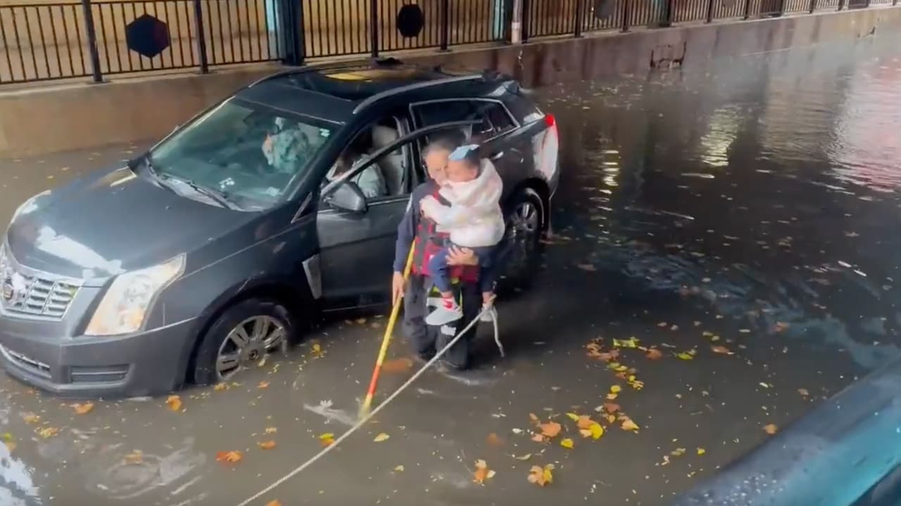 Rescatista salva a una niña de un auto atrapado por inundaciones en Nueva Jersey