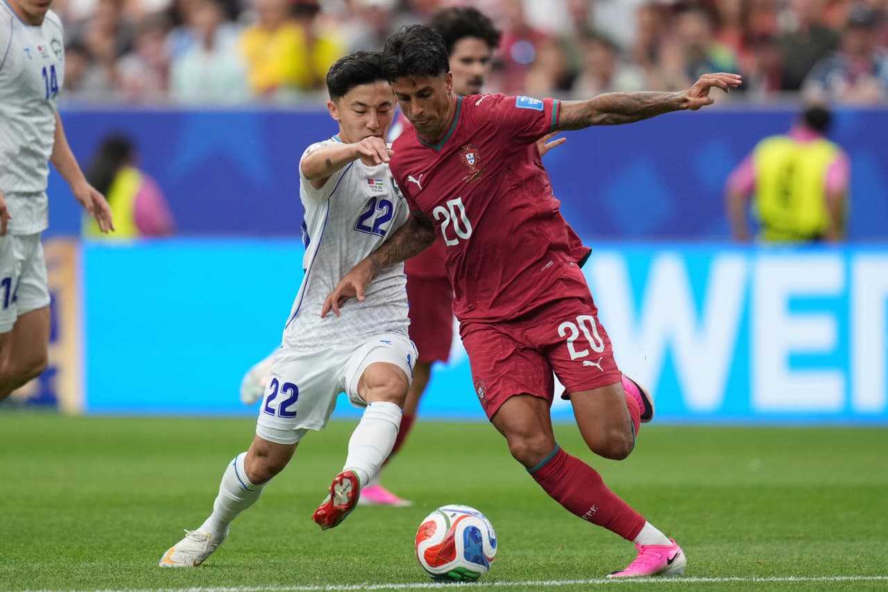 Joao Cancelo (20) de Portugal disputa el balón con Abbosbek Fayzullaev (22) de Uzbekistán durante el partido de fútbol del Grupo K de la Copa Mundial entre Portugal y Uzbekistán en Houston