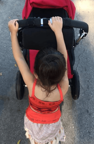 Giulietta se está graduando con honores como hermana mayor. Así vemos a la pequeña llevando la carreola de su hermanito pequeño.