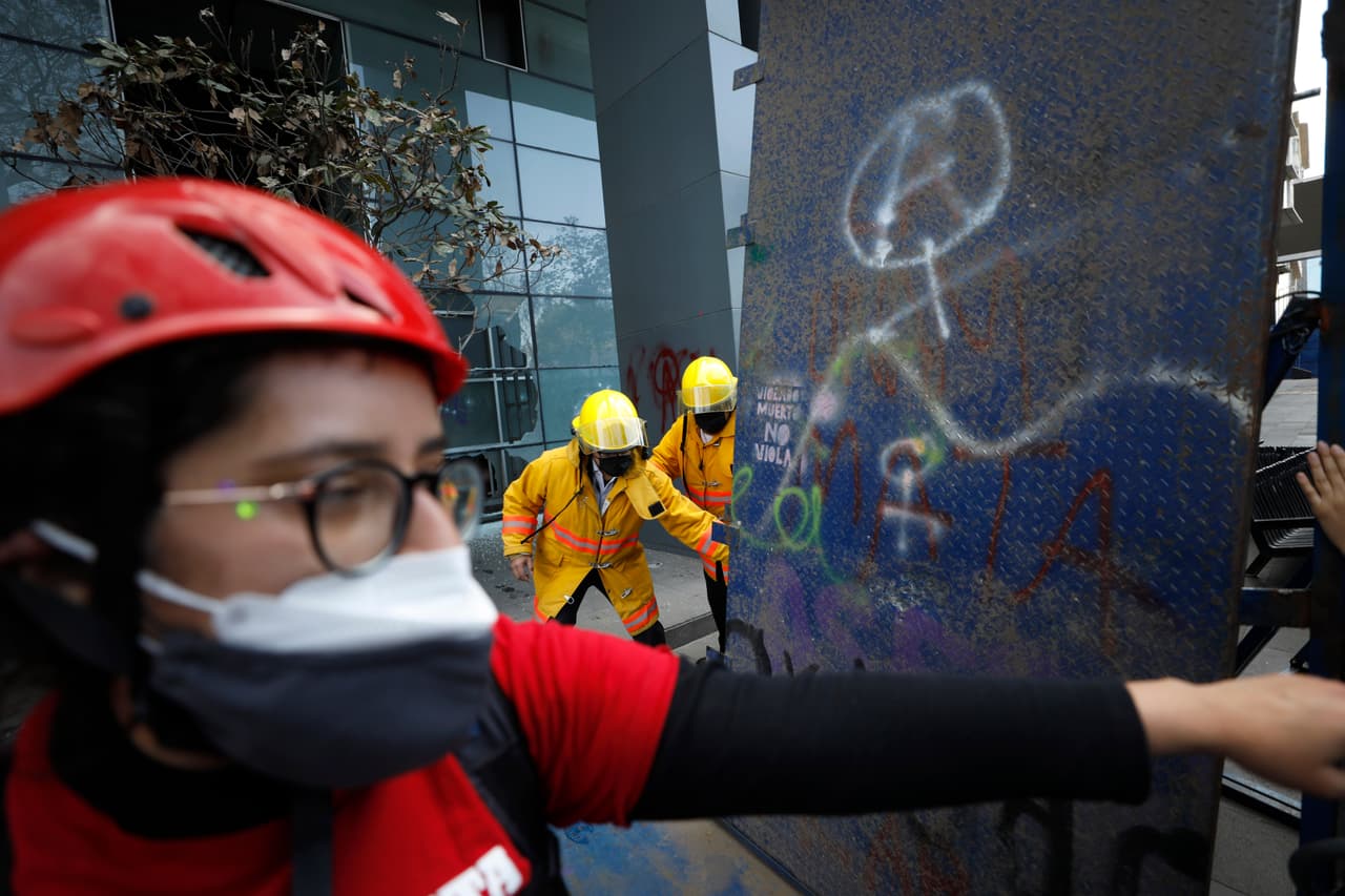 Los paramédicos caminan luego de que un grupo de mujeres atravesaron una barricada y destrozaron el vestíbulo del hotel Hilton de la Ciudad de México, como protesta ante los feminicidios registrados en el país.