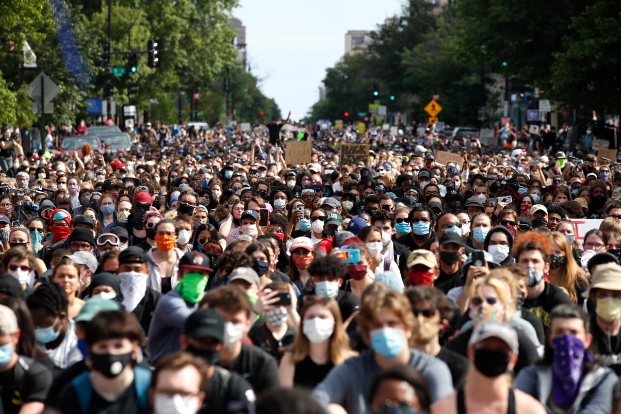 Un grupo de manifestantes -algunas personas con máscaras faciales- marcha mientras protesta en Washington D.C., el martes 2 de junio de 2020.