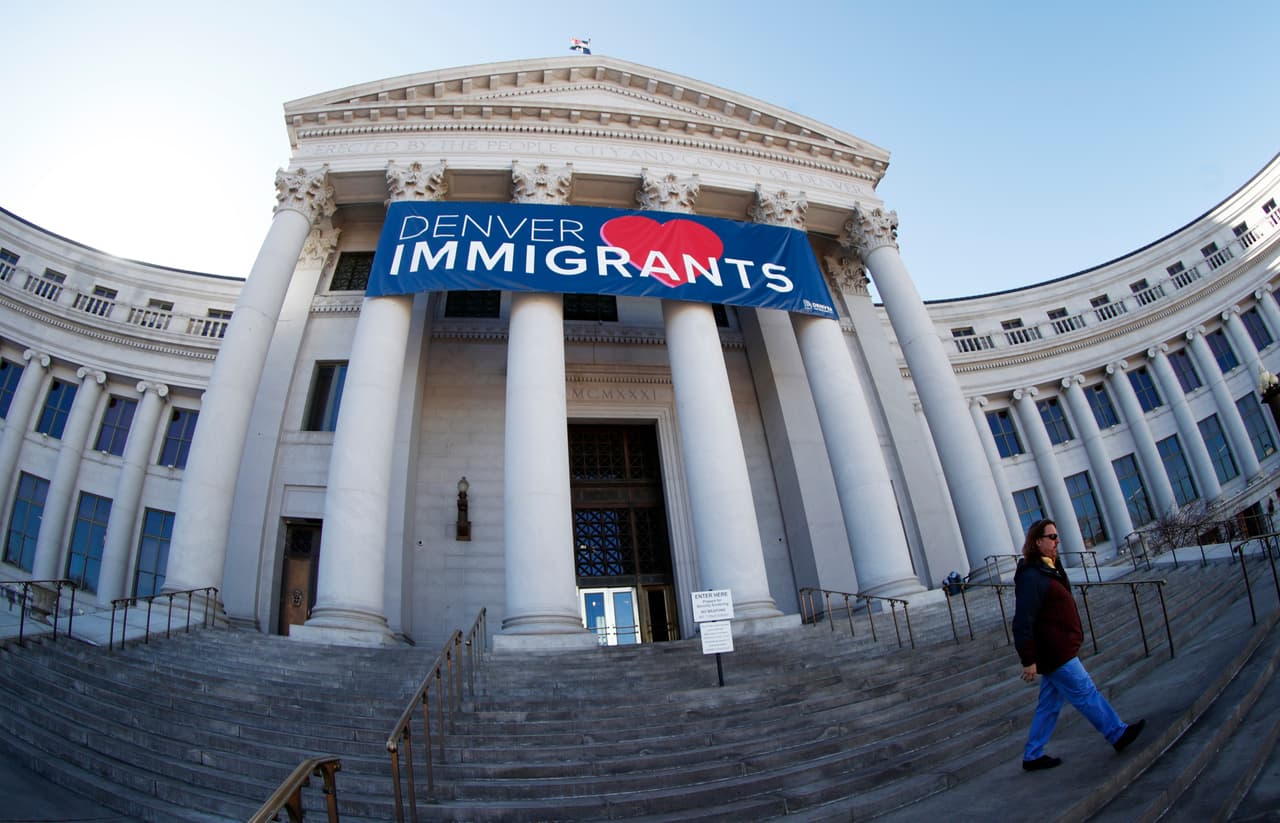 ARCHIVO - En esta foto del 26 de febrero del 2018, se ve un cartel que saluda a los inmigrantes sobre la entrada principal del edificio municipal de Denver. (AP Foto/David Zalubowski)