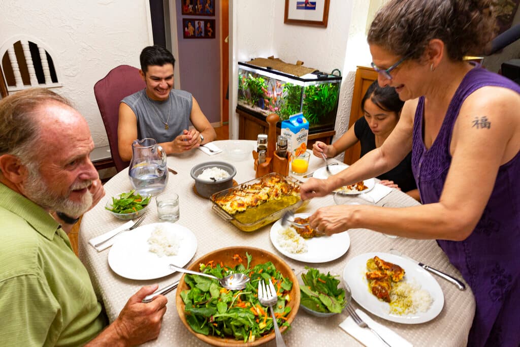 ARCHIVO. En esta foto del lunes 26 de agosto de 2019, Fernando, un solicitante de asilo hondureño de 18 años, sonríe mientras disfruta de una cena con su familia anfitriona.