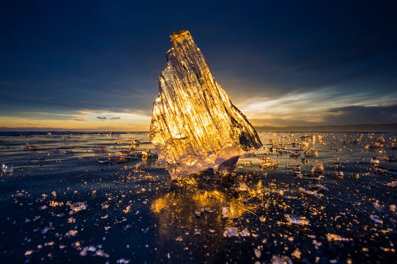 <b>Lago Baikal, Rusia.-</b> "Para capturar esta imagen, me puse boca abajo alineando mi cámara con el bloque de hielo y poniendo el sol en la distancia. El bloque de hielo se iluminó con tonos dorados, emitiendo un calor visual que desmentía el frío de este maravilloso lugar."/ Crédito: Edward Graham, Estadous Unidos. Muy elogiada en la Categoría La belleza de la luz / 
<a href="https://www.tpoty.com/t" target="_blank">Tpoty</a>