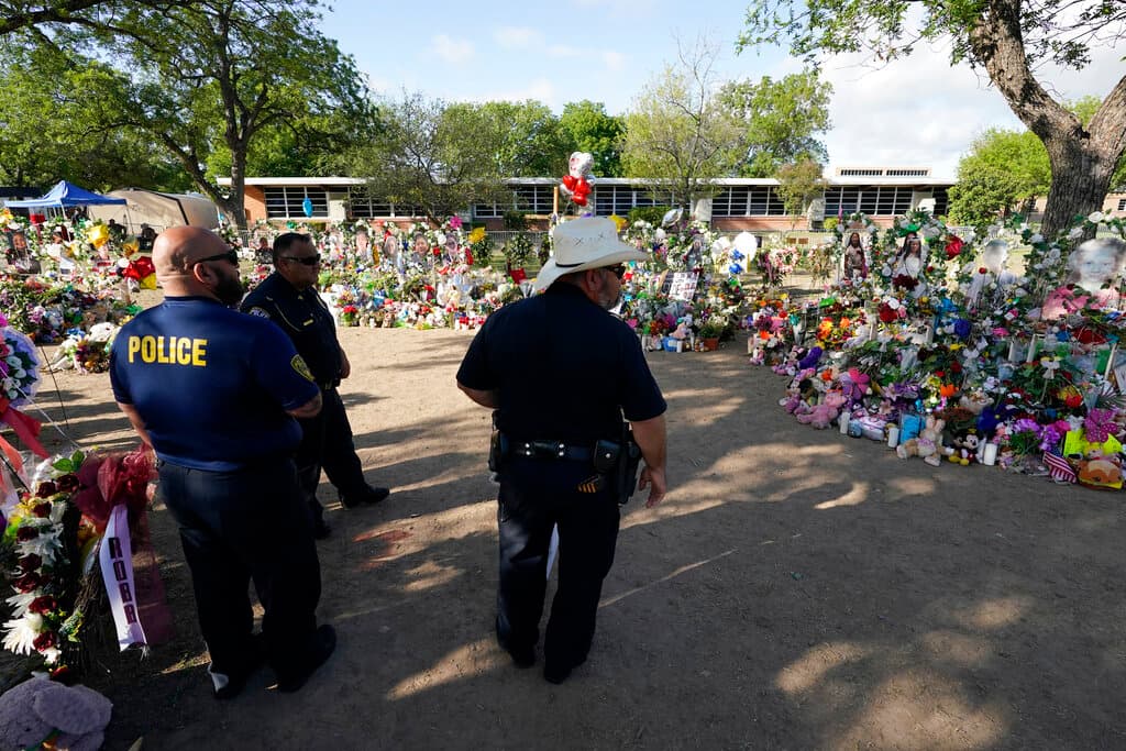 Miembros del departamento de policía de Pharr, Texas, visitan el memorial de la escuela.