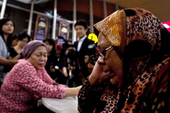 Familiares de los pasajeros del Malaysia Airlines vuelo MH17 lloran ante la tragedia.