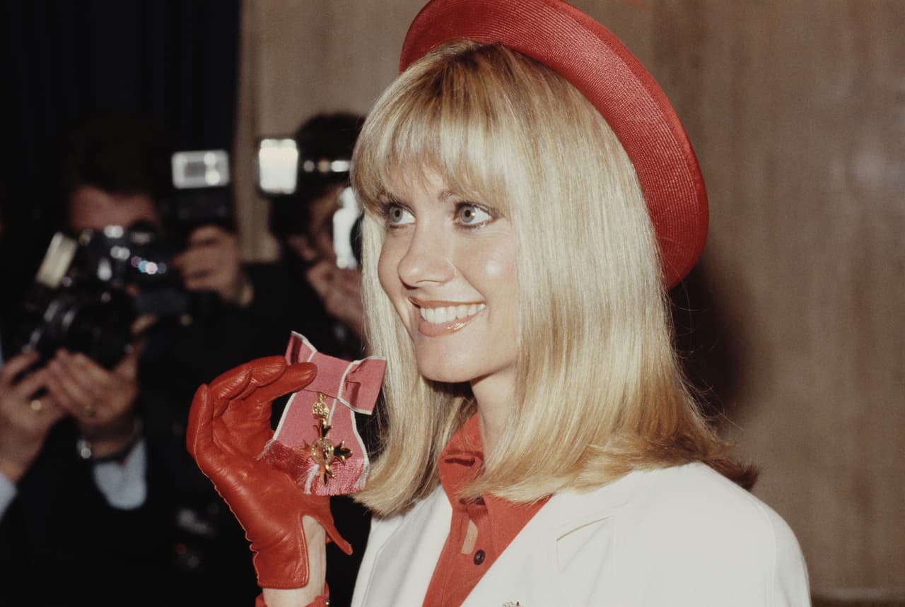 Olivia Newton-John, durante una ceremonia en el Palacio de Buckingham en Londres, en 1979. Entre 1973 y 1983, Newton-John estuvo entre los artistas más populares del mundo. Tuvo 14 sencillos entre las 10 más populares en Estados Unidos, ganó cuatro premios Grammy, protagonizó “Grease” con John Travolta y “Xanadu” con Gene Kelly.