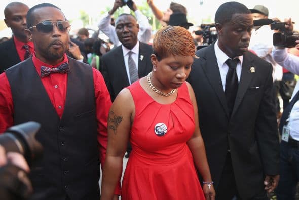 Con la cara visiblemente marcada por el dolor, la madre del difunto apareció vestida de rojo.