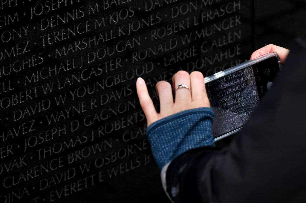 Una mujer toma una fotografía de los nombres en el Muro Conmemorativo de los Veteranos de Vietnam, el 30 de mayo de 2021, en Washington DC.