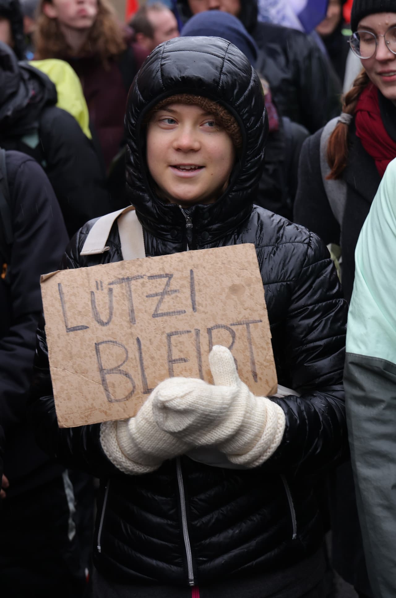 KEYENBERG, GERMANY - JANUARY 14: Swedish climate activist Greta Thunberg holds a sign that reads: "Luetzerath stays" as she joins a protest march over the pending razing of the nearby settlement of Luetzerath on January 14, 2023 in Keyenberg, Germany. Police have been evicting environmental activists over the last few days who had occupied the abandoned Luetzerath settlement and who were seeking to prevent Luetzerath's demolition that will make way for an expansion of the adjacent Garzweiler II open cast coal mine. The North Rhine-Westphalia state government of German Christian Democrats (CDU) and Greens has approved the demolition and the coal mine expansion, while at the same time announcing an accelerated phase out of coal-fired energy production in the state from 2038 to 2030. Other nearby settlements that were also slated for demolition will now be spared, though critics point out that Germany has sufficient energy production capacity and does not need the coal lying beneath Luetzerath. (Photo by Sean Gallup/Getty Images)