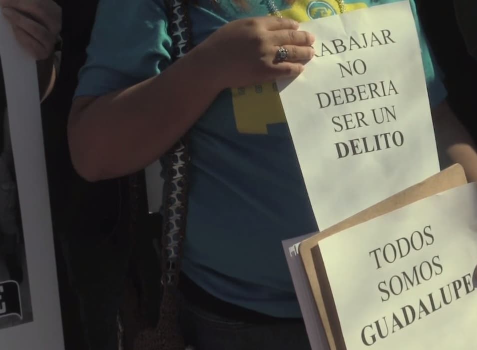 Trabajar no es un delito dice una de las pancartas en la protesta frente al ICE.