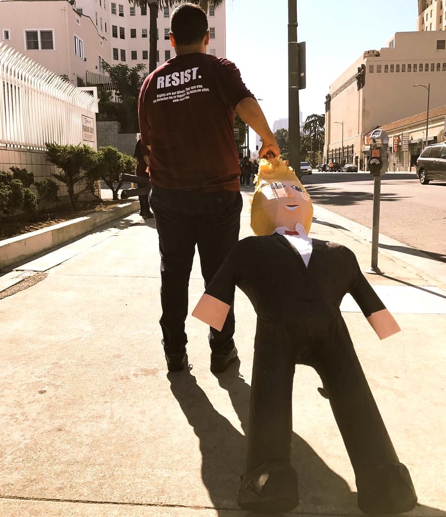 Manifestante en marcha de resistencia contra Donald Trump arrastra una piñata.