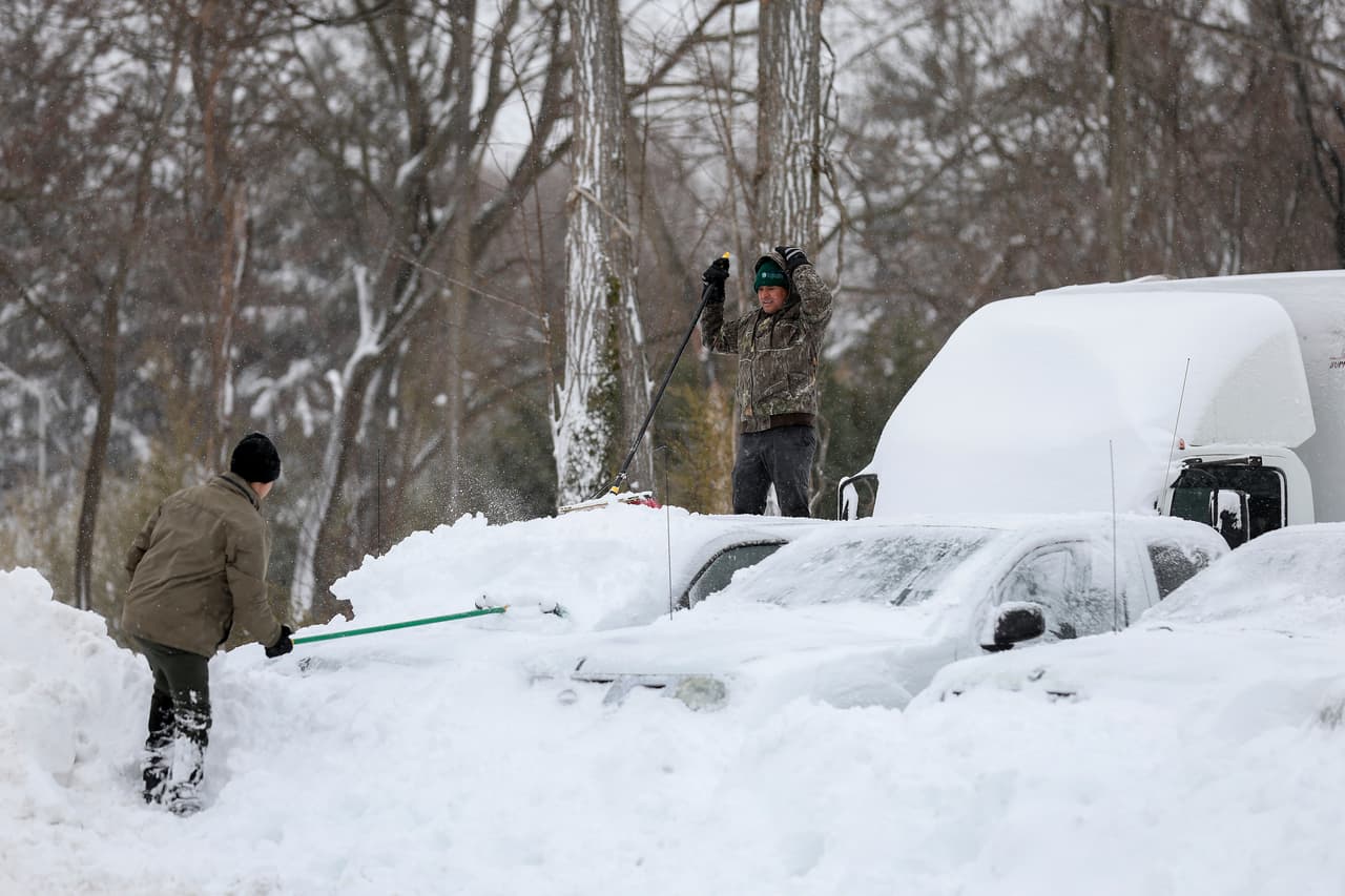 Un hombre limpia su coche de la nieve en Washington.