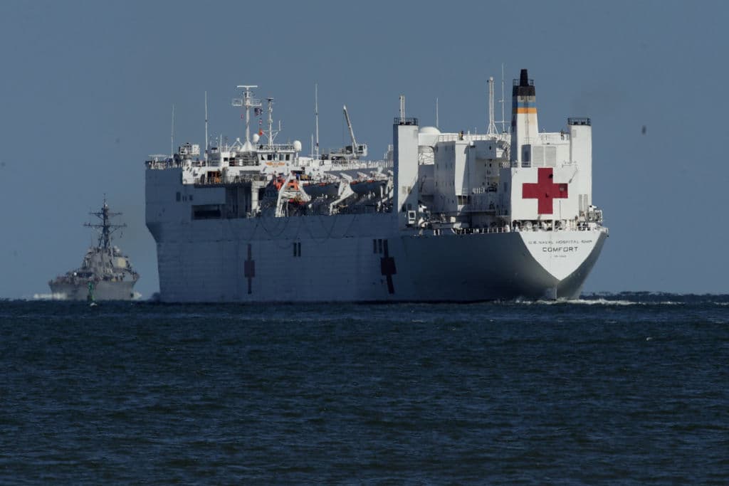 HAMPTON, VA - SEPTEMBER 29: USNS Comfort, the naval hospital ship, leaves the harbor as USS McFaul (DDG-74) is seen in the background September 29, 2017 in Hampton, Virginia. The USNS Comfort is being deployed to support relief efforts in the aftermath of Hurricane Maria in Puerto Rico. (Photo by Alex Wong/Getty Images)