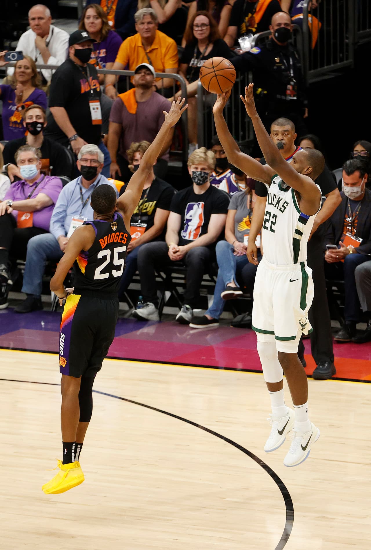 Khris Middleton # 22 de los Milwaukee Bucks dispara contra Mikal Bridges # 25 de los Phoenix Suns durante la segunda mitad del segundo juego de las Finales de la NBA.