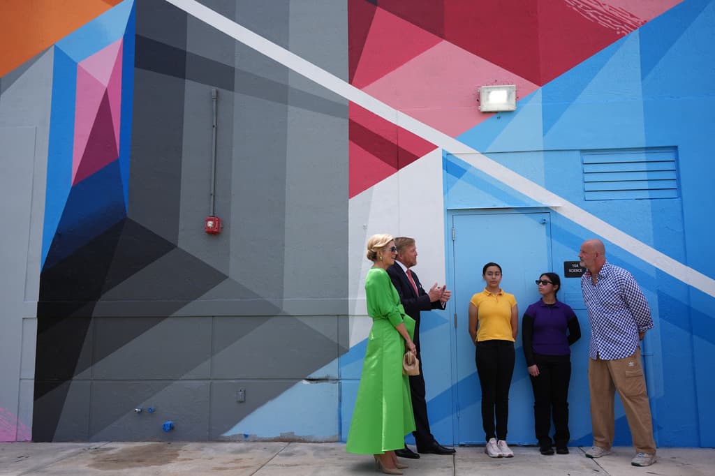 La reina Máxima y el rey Guillermo conversan con el artista neerlandés David Louf, conocido como Mr. June, quien es autor de uno de los murales de la escuela Dr. Henry W. Mack.