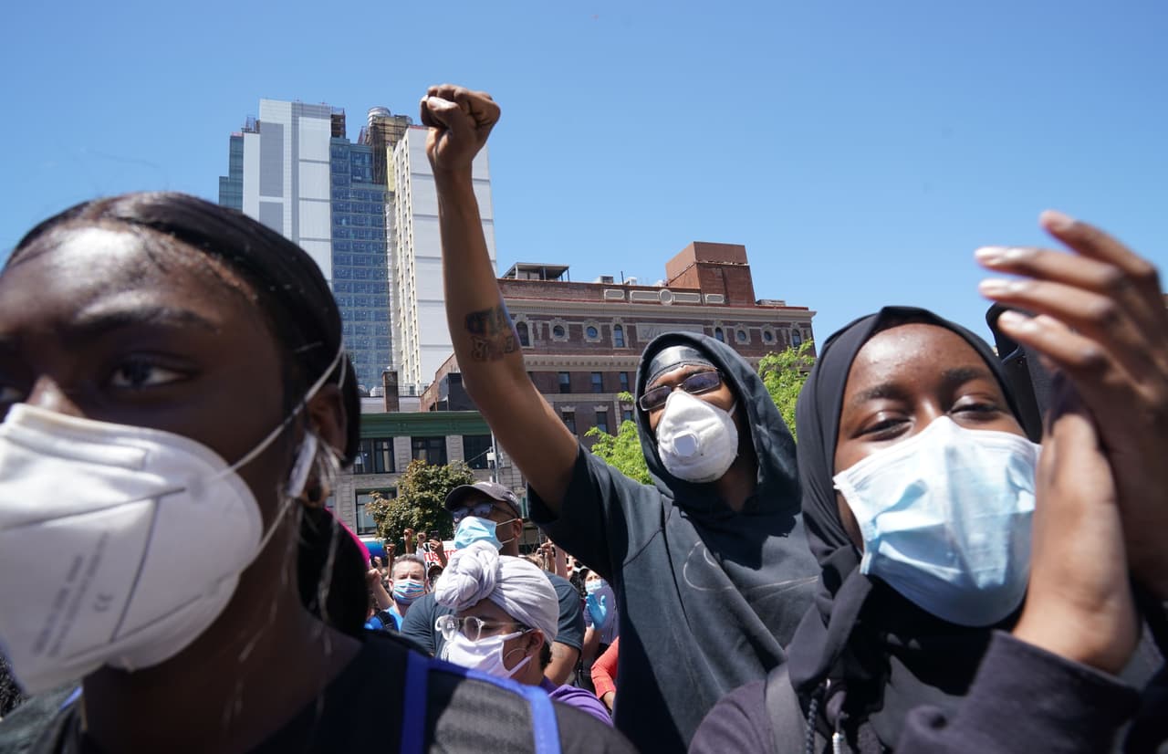 Con mascarillas para evitar un posible contagio con el coronavirus, los manifestantes se reunieron en Nueva York en medio de las crecientes tensiones raciales que han dejado dos personas muertas en las protestas de las últimas cuatro jornadas.