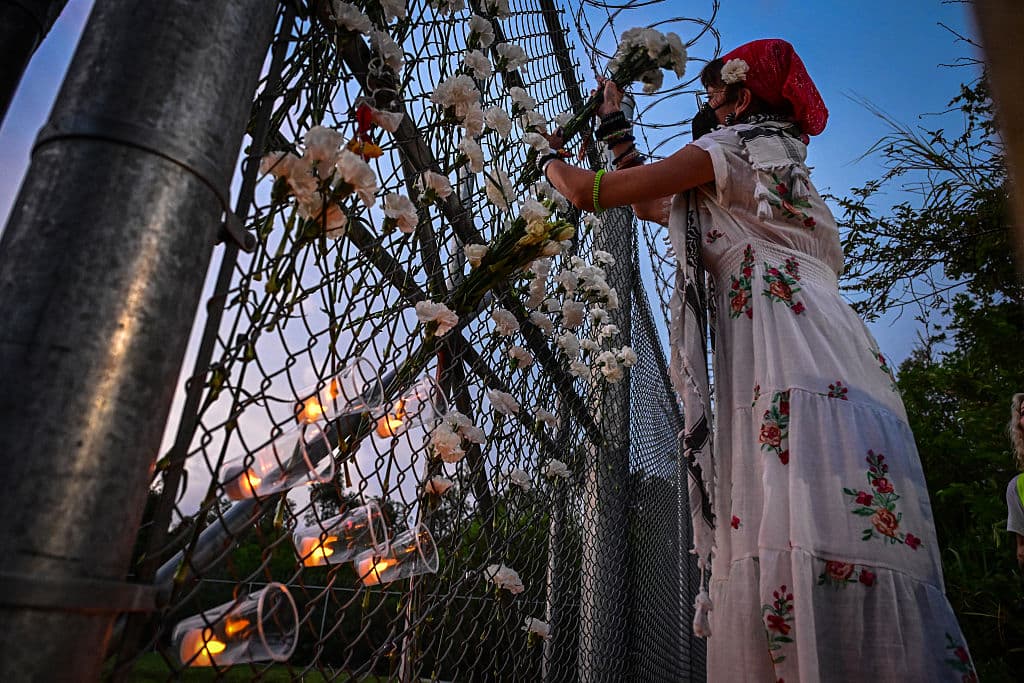 Con claveles blancos y veladoras, los manifestantes recordaron las vidas de los 9 migrantes que han muerto este año en custodia de las autoridades de EEUU.