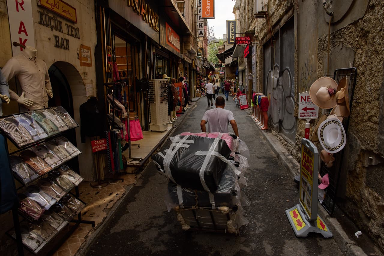 Un hombre empuja un carrito cargado de mercancías por el distrito comercial de Eminönü.
