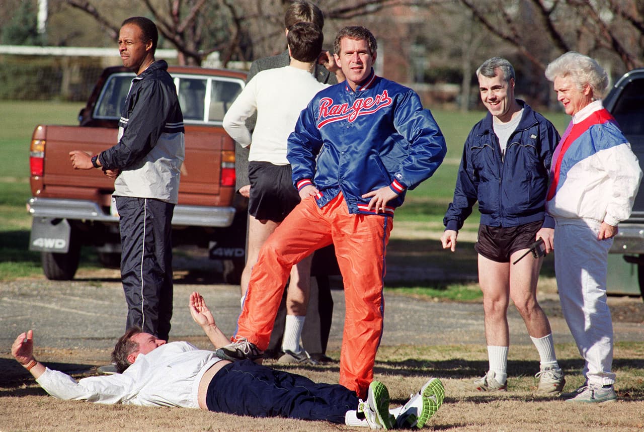 George W. Bush (1946) fue capitán del equipo de cheerleaders en los años 60. Aquí, en la fotografía, le pone un pie a su papá en 1990, cuando era presidente. Una imagen premonitoria para el presidente número 43 de Estados Unidos. Elegido en 2001, durante su gobierno el país sufrió el peor ataque desde Pearl Harbor. El 9/11 desencadenó la guerra en Afganistán, para acabar con Al Qaeda, y en Iraq, para derrocar a Sadam Hussein con la excusa de unos informes de inteligencia amañados que hablaban de unas supuestas armas de destrucción masiva en poder del regimen. Las armas nunca aparecieron y las últimas tropas estadounidenses saldrán de Afganistán el próximo 31 de diciembre.