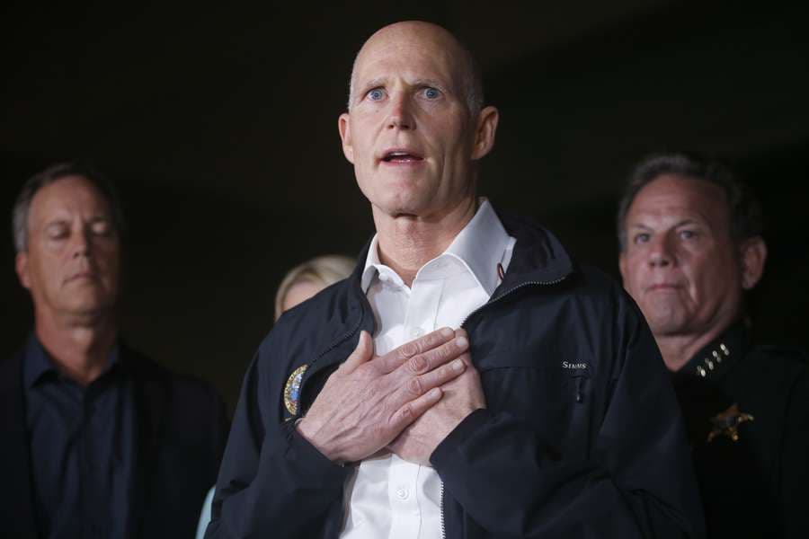 Florida Gov. Rick Scott gestures as he speaks during a news conference near Marjory Stoneman Douglas High School in Parkland, Feb 15.