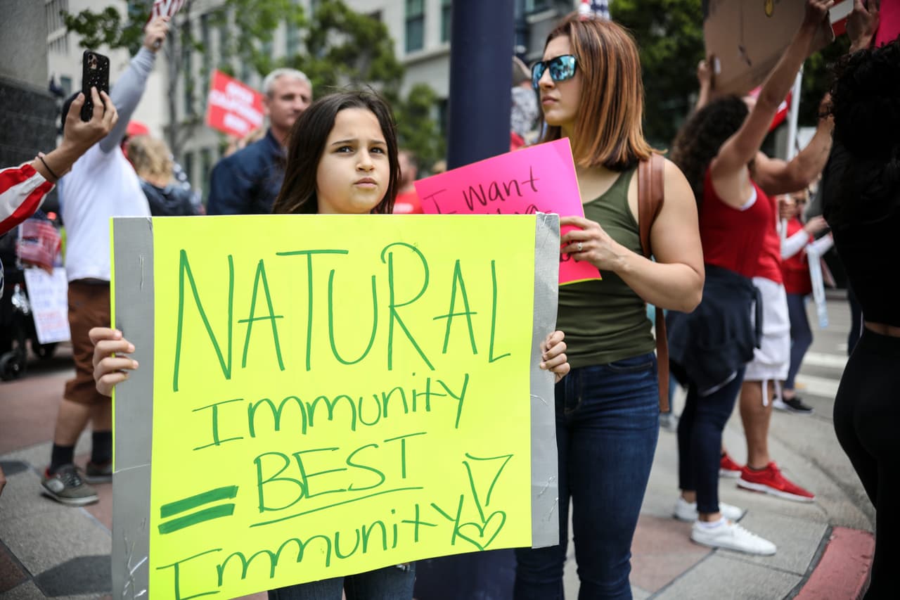 <b>“La inmunidad natural es la mejor inmunidad”</b>,
<b> </b>uno de los carteles vistos en San Diego, California, el 18 de abril. Según un reporte de la agencia AP, algunas de estas protestas han sido promovidas por grupos de Facebook y cuyos organizadores a veces son difíciles de identificar. Otras están respaldadas por grupos financiados por donantes republicanos, algunos vinculados con Trump, de acuerdo con la agencia.