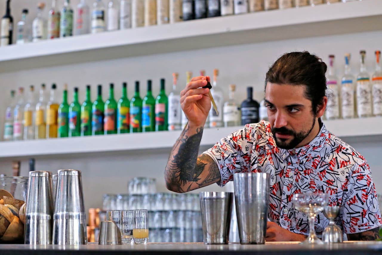 El CBD no da el "high", pero hay quienes aseguran que proporciona calma. También se cree que ayuda a aliviar el dolor, la ansiedad, que ayuda a dormir y te mantiene concentrado. Pero todas estas afirmaciones provienen de estudios con ratas o ratones. Aunque se han hecho estudios con personas, han sido en muy pequeña escala. En la imagen, Maxwell Reis, añade gotas de cannabidiol a una bebida en el restaurante Gracias Madre, en West Hollywood, California. 
<br>