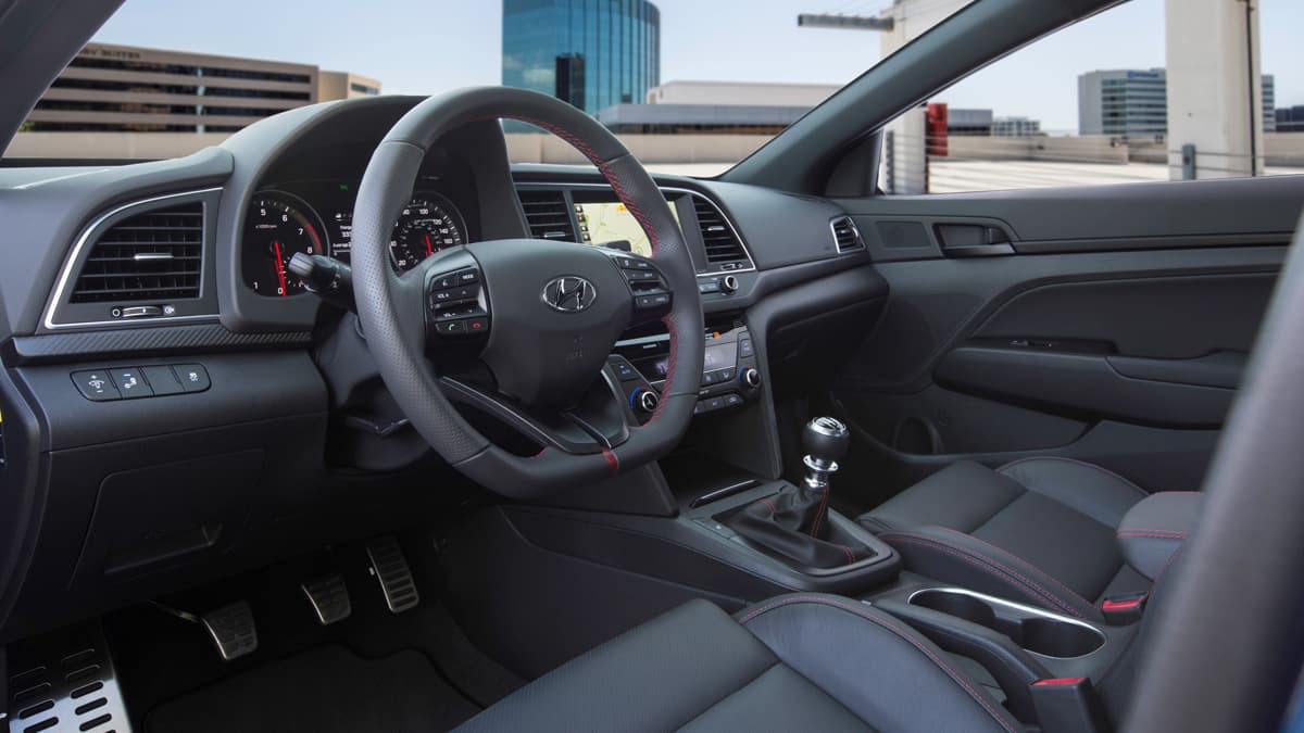 Al interior del Hyundai Elantra 2017 resaltan los asientos deportivos cubiertos en piel con la inscripción "Sport" y costuras en rojo haciendo contraste.