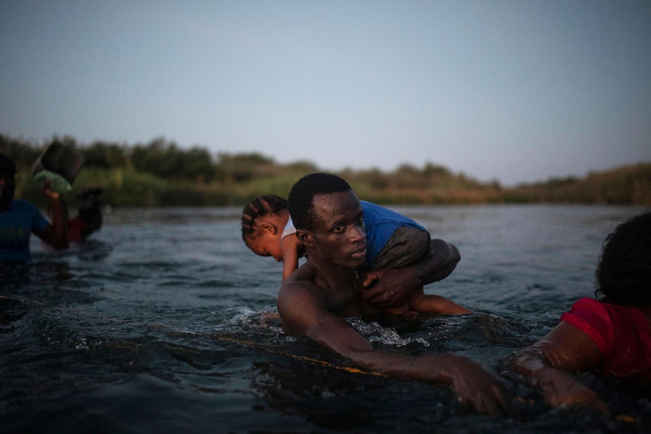 <b>Cruzando el río</b>
<br>
<br>Un joven haitiano lleva sobre sus hombros a una niña al cruzar el Río Grande, entre Ciudad Acuña, México y Del Rio, Estados Unidos. Sucedió el 19 de septiembre.
<br>