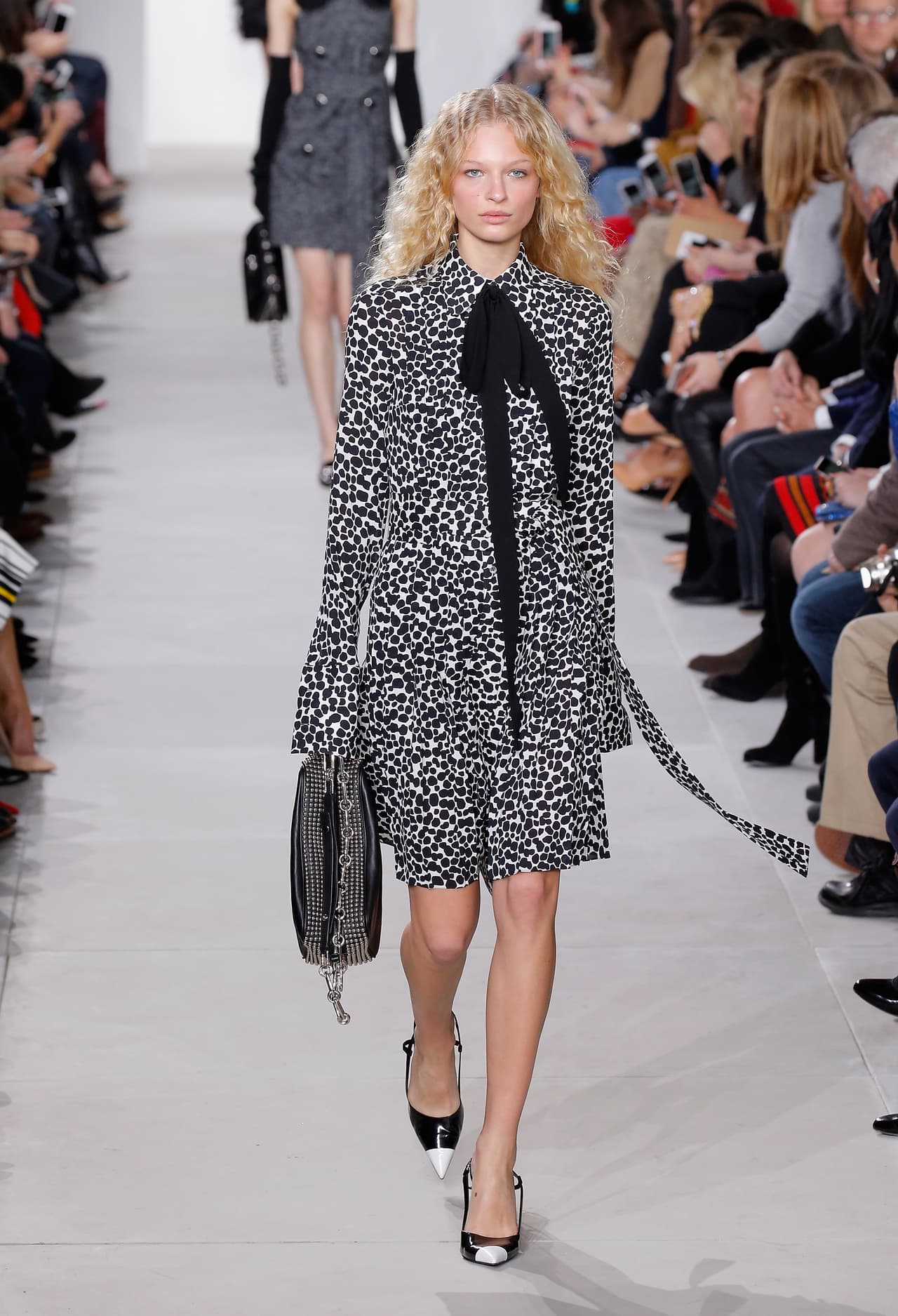 El estilo de vestido camisero de lazos anudados al cuello y de tonos blanco y negro como este de Michael Kors, además de estar en todas las vitrinas esta temporada, le viene perfecto a una actriz que quiere cumplir nuevos roles como profesora.