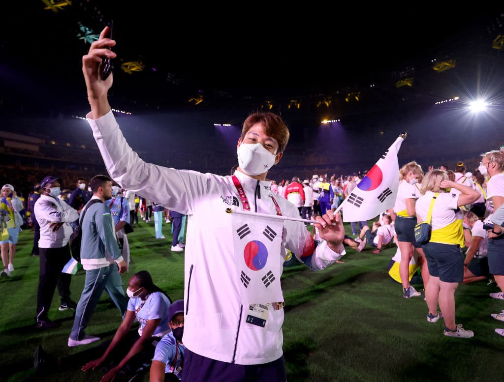 Cerca de los australianos se puede ver a esta atleta coreana junto a sus compañeros haciéndose un selfie en el terreno del estadio, mientras desfilaban.