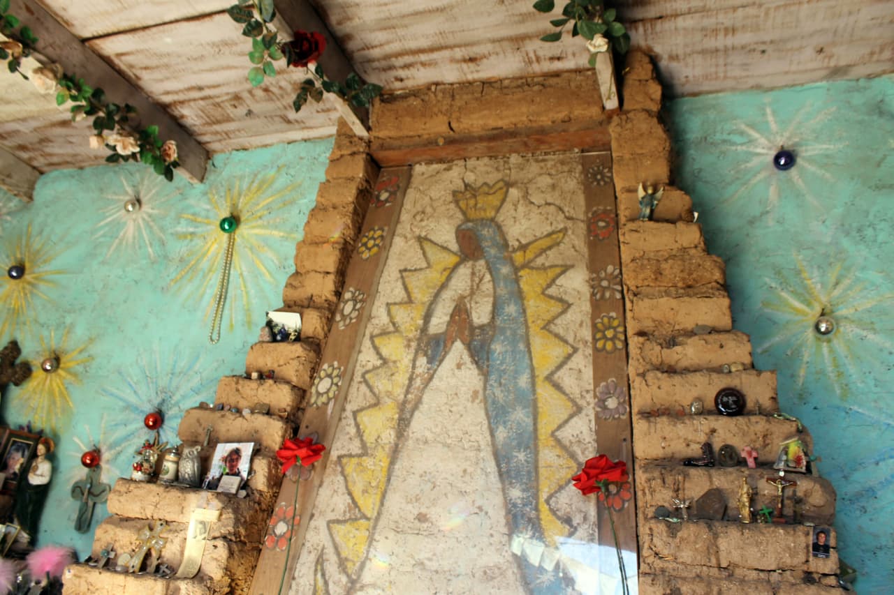 Al lado del mural de la virgen los visitantes dejan ofrendas y fotos en honor a sus seres queridos.