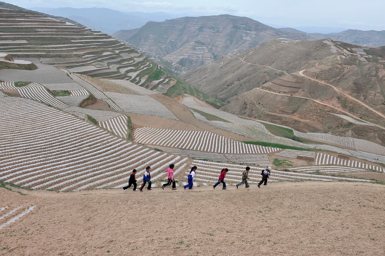 <b>China.</b> Estudiantes de una escuela rural en una montaña a más de 6,500 pies de altura, caminan de regreso a su escuela después de almorzar en el condado de Min, provincia de Gansu. 1 de junio de 2011.
