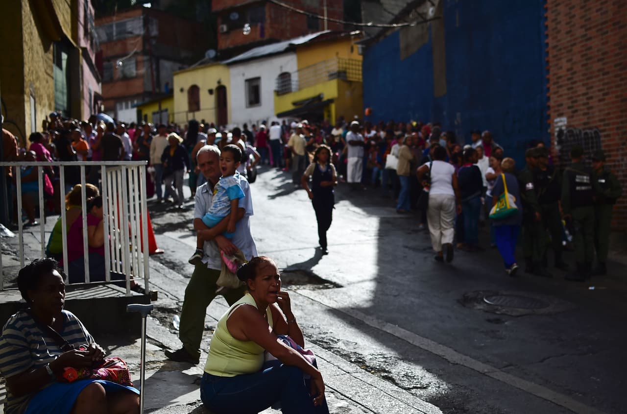 Cientos de personas hacen fila para comprar comida a las afueras de un mercado en el humilde barrio de Lídice en Caracas.