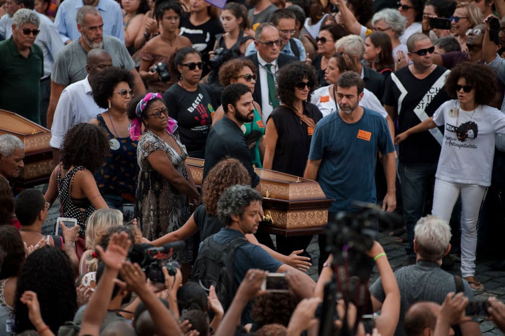 Politicians, friends and relatives carry the coffin of slain Brazilian councilwoman and activist Marielle Franco, and Anderson Pedro Gomes who was driving her and was also shot dead, during their funeral at Rio de Janeiro's Municipal Chamber in Brazil on March 15, 2018. Brazilians mourned Thursday for a Rio de Janeiro councilwoman and outspoken critic of police brutality who was shot in the city center in an assassination-style killing on the eve. Some 1,000 people stood under the tropical sun outside City Hall to greet the coffin of Marielle Franco, 38, who was murdered late Wednesday. / AFP PHOTO / Mauro Pimentel (Photo credit should read MAURO PIMENTEL/AFP/Getty Images)